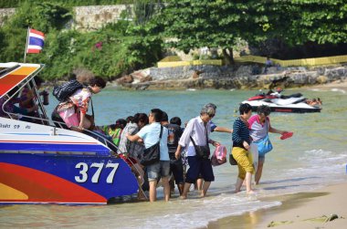 Mutlu turistler bir tekne gezisi nin ardından tekneden inerler. Pattaya, Tayland 2014. 
