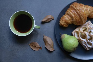 Kahve kompozisyonu, bir fincan kahve ve koyu arkaplanda güzel bir pasta. Kahve havası..