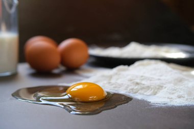 Koyu arkaplanda yumurta ve buğday unu (pişirme, ekmek ve diğer hamur işleri için malzemeler))