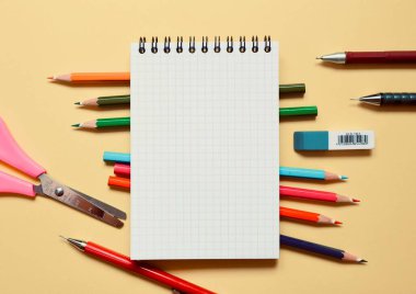 Okul kırtasiyesi ve bej arka planda mesaj için alan. Yukarıdan görünüşü.