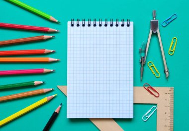 Renkli bir arka planda okul kırtasiyesinin düz kompozisyonu. Yukarıdan görünüşü.