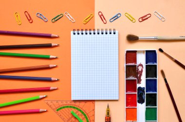 Renkli bir arka planda okul kırtasiyesinin düz kompozisyonu. Yukarıdan görünüşü.