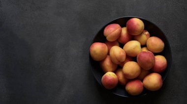 Lezzetli, renkli, koyu arkaplanda taze kayısılar. Yukarıdan görünüşü.