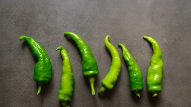Koyu arkaplanda taze yeşil biberler. Üst görünüm.