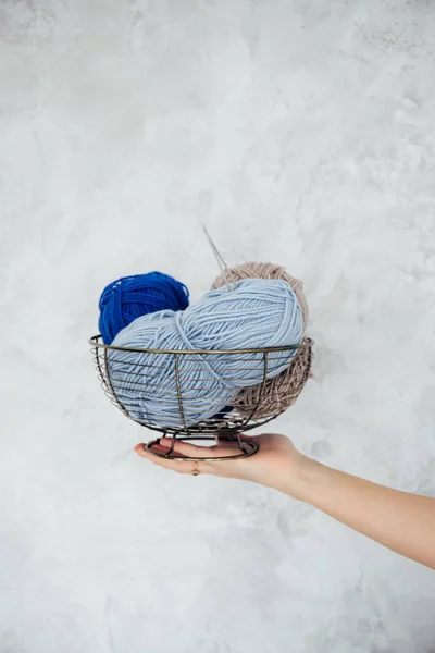 Clews of colored wool yarn in basket