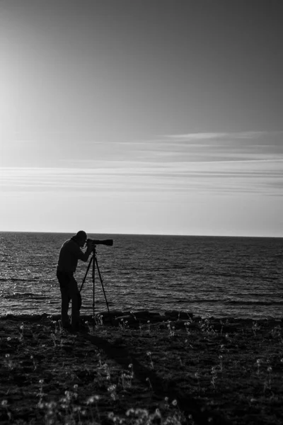 Black and white photo af an photographer at the sea