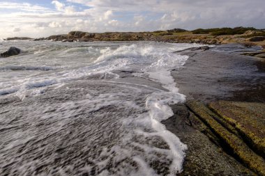 rüzgarlı bir gün beyaz bulutlar arka plan ile ön plan ve mavi gökyüzü kayalıklardan denize sıfır tarafından