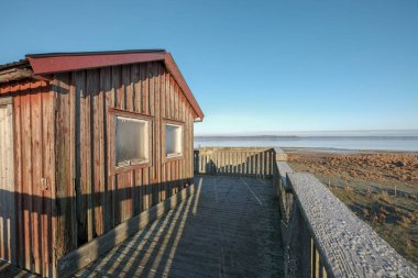 Eski kırmızı ev iki pencere ve göl manzaralı