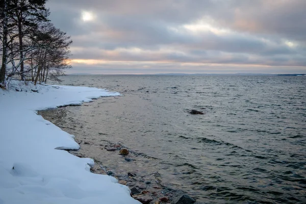 Uma praia com neve sobre e por do sol no fundo — Fotografia de Stock