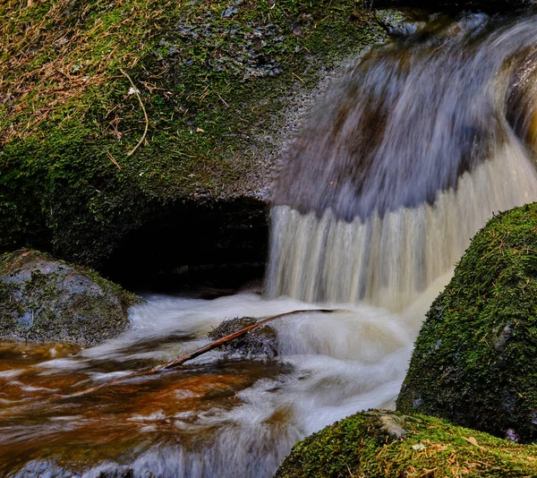 close-up of a small waterfall with mossy stones