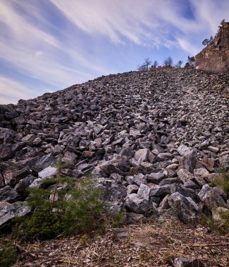 arka planda mavi gökyüzü ile büyük taş çöp
