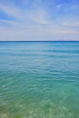 turkuaz renk sakin deniz ve mavi gökyüzünde bazı bulutlar