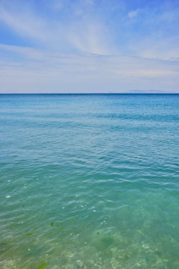 turkuaz renk sakin deniz ve mavi gökyüzünde bazı bulutlar