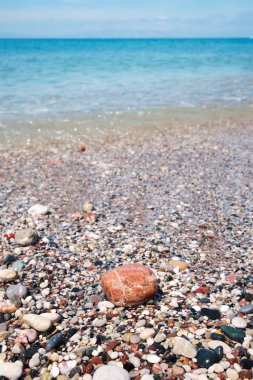ön planda turuncu taş ve arka planda turkuaz deniz