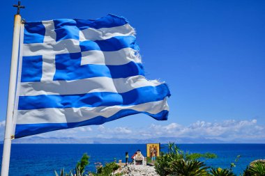 yunan bayrağı arka planda dua ve deniz için yer ile güneşli bir gün rüzgarsal sallayarak