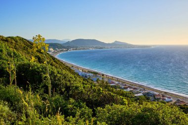 bulutsuz bir yaz akşamı altında orman ve deniz ile yamaç