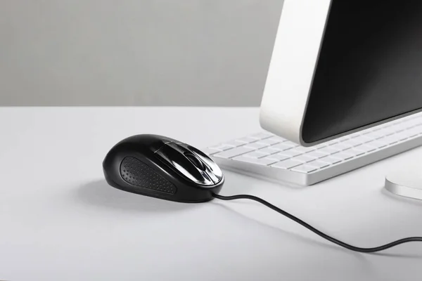 computer, mouse and keyboard on a white desk with copy space