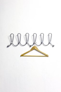 Beyaz bir duvar üzerinde elbise askısı