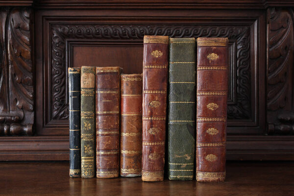 старые книги, сложенные на старинной деревянной мебели
