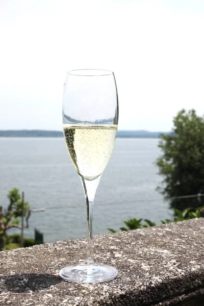 glass with champagne wine on a stone handrail