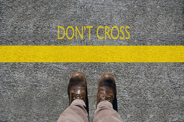 man 's shoes view from above, words don' t cross and a limit line
 