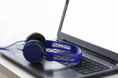 mavi kulaklıklar pc ekranında cliipng yolu ve kopyalama alanı ile bir laptot bilgisayarda dinlenme