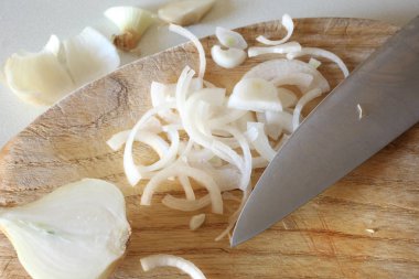 bir bıçak bıçak ile ahşap bir tahta üzerinde doğranmış soğan üzerinde yakın