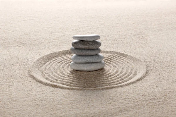 zen stones piled on raked sand with copy space for your text