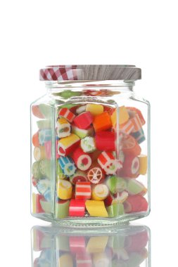 kırpma yolu ile beyaz arka plan üzerinde izole kopya alanı ile renkli şekerler yarım dolu bir cam kavanoz 