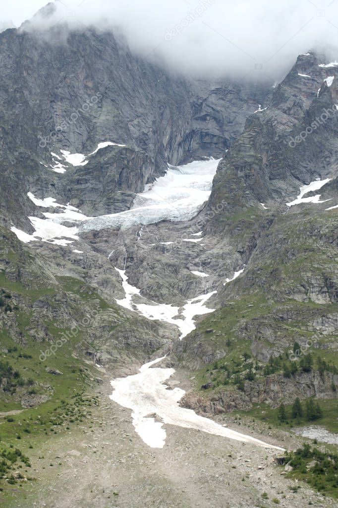 global warming and climate change effect concept; melting glacier on the mountains