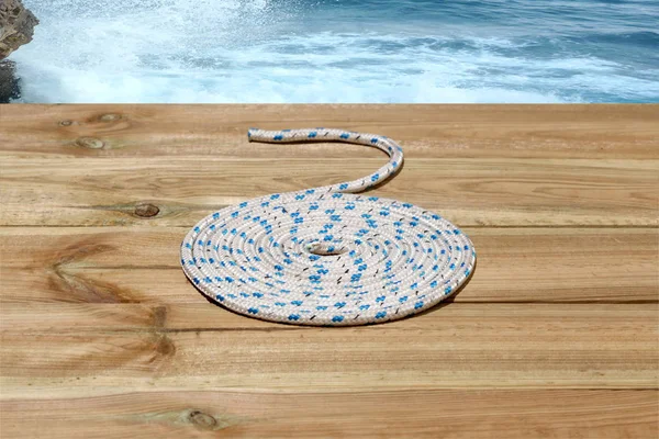 nautical rope in spiral shape on a  wooden  deck with copy space for your text