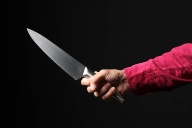 Erkek eli siyah arkaplanda izole edilmiş bir bıçak tutuyor. Metnin için kopyalama alanı var., 