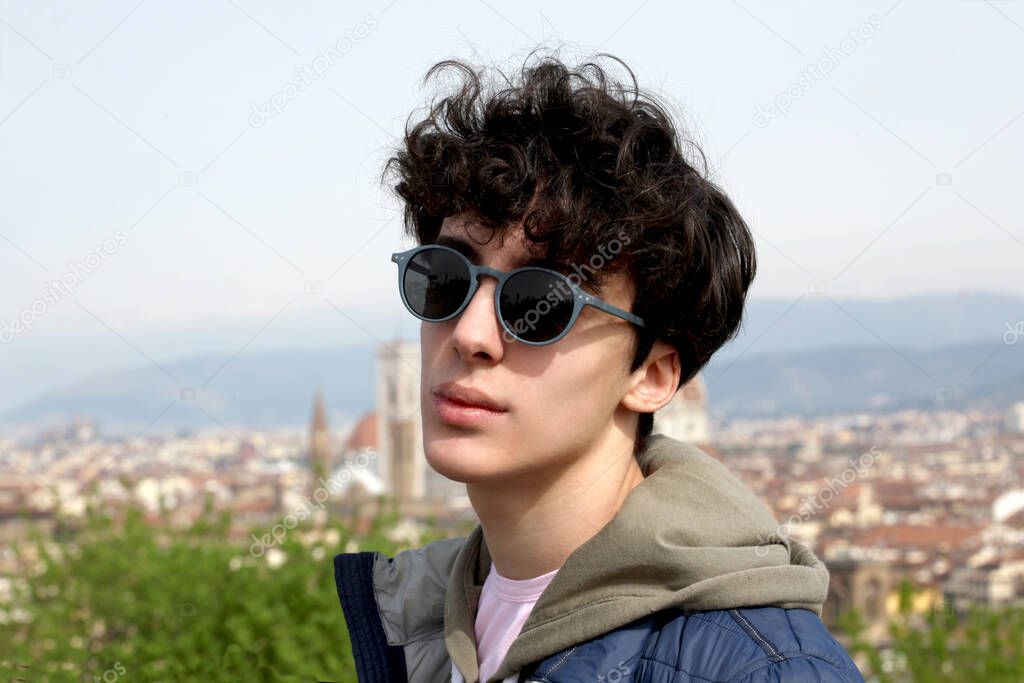 portrait close up of a male teenager with the city of Florence on the background with copy space for your text