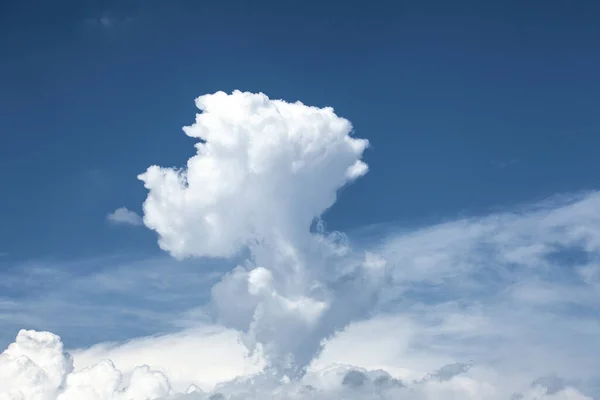 a cloud in  mushroom cloud shape on a blue sky with copy space for your text