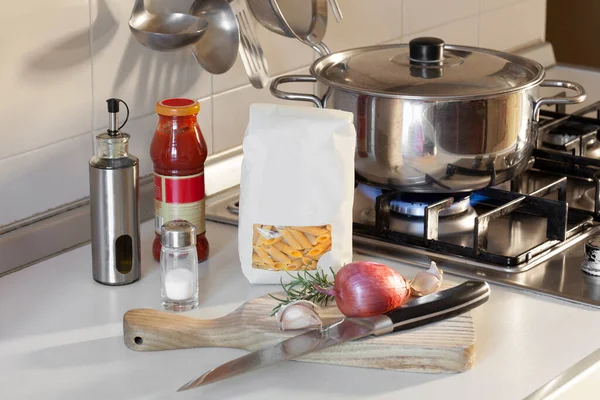 pack of penne pasta on a kitchen shelf with cooker with copy space for your text