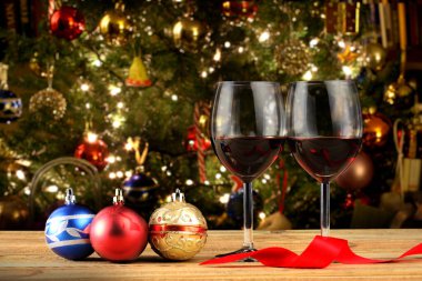 İki kadeh kırmızı şarap ve noel süsü ahşap bir masada metin için fotokopi alanı ile