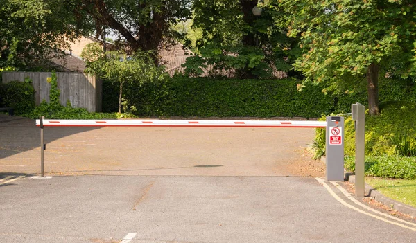 A rising Barrier at the entrance to a Car Park with post for keypad