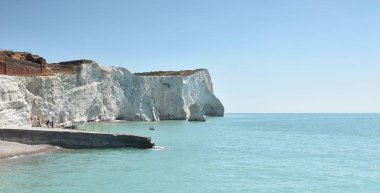 Beyaz tebeşir kayalıklarla ön planda eski İskelesi ile İngiltere'nin güney kıyısında East Sussex'deki / daki Seaford kafasına
