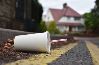Dikkatsizce atılan içki veya saman içme ile soda kapsayıcı bir kentsel sokak sefalet içinde yatıyor