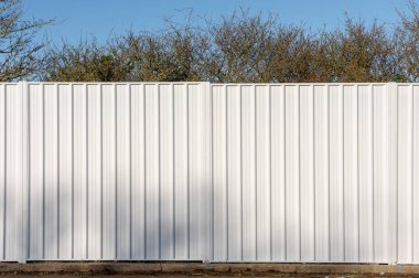 Ormanlık alanda beyaz metal iki panel çit