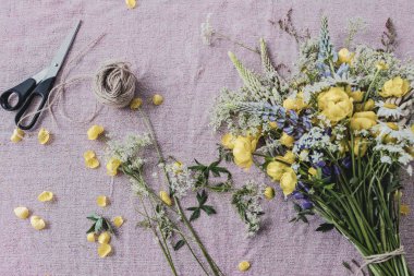 Pembe masa örtüsünün üzerinde sarı bir çiçek buketi