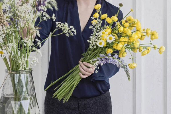 woman florist making flower bouquet on table