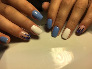 Beyaz tasarım ve hafif bir arka plan üzerinde mavi piyon ile şık mavi manikür