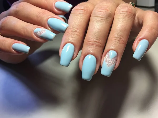 fashionable blue manicure with white lace and triangular hole