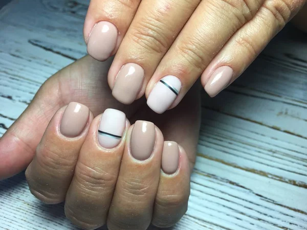 fashionable beige manicure with a design and silver ribbon on short nails