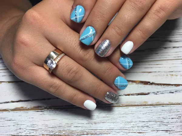 fashionable blue manicure with a shiny design and white color