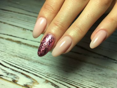 uzun oval çivi ile altın bir tasarım üzerinde moda bej manikür