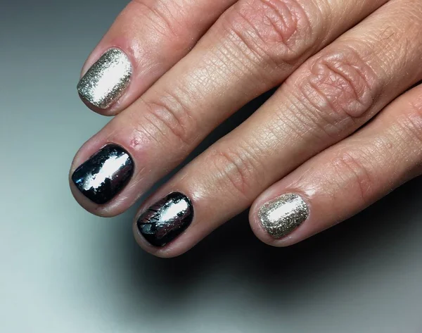 Fashionable silver manicure with black foil on short nails