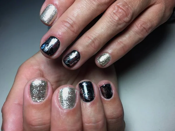 Fashionable silver manicure with black foil on short nails