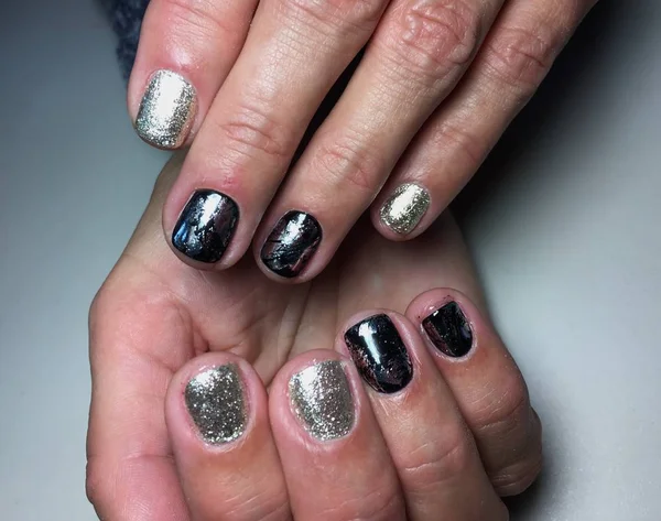 Fashionable silver manicure with black foil on short nails